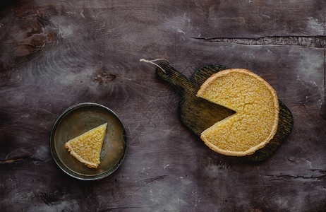 木板和盘子上美味柠檬派的顶视图图片