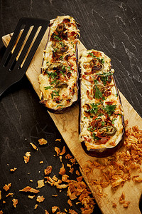 黑桌上的茄子奶酪和墨西哥胡椒的美味砂锅图片