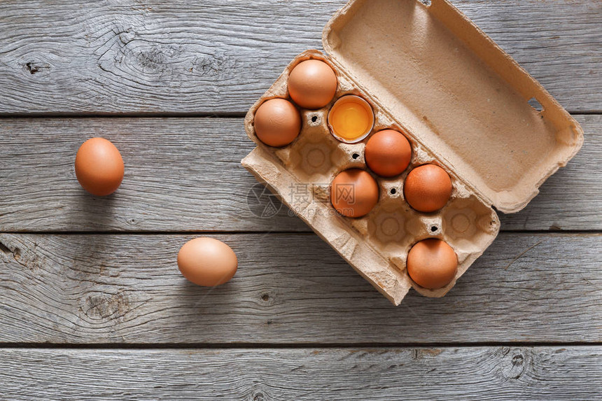 新鲜的鸡蛋背景棕色和白色鸡蛋在工艺纸箱包装在仿古木桌上与复制空间顶视图天然健康食品和图片
