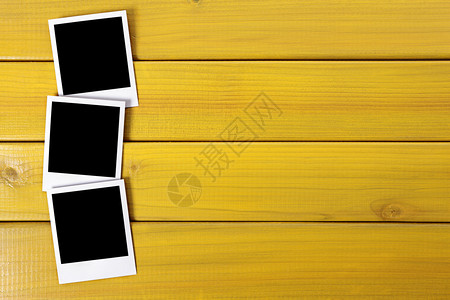 木质桌上或桌子上有三张空白的照片指图片