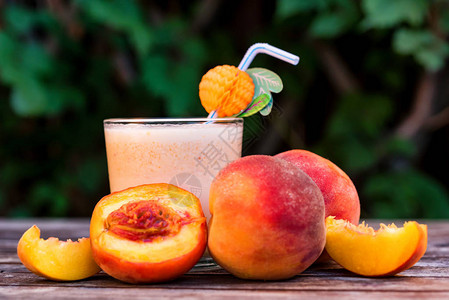 以桃酸奶和木质表面的新鲜桃子为密封杯子图片
