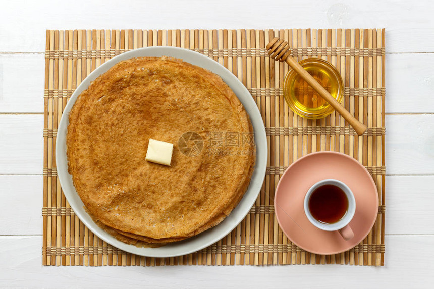 盘子里有黄油和蜂蜜的热煎饼图片