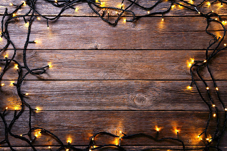 灰色木桌上的圣诞花环灯图片