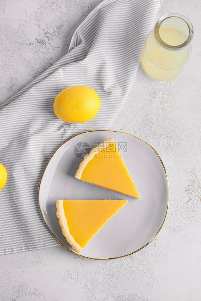 桌上放着美味自制柠檬派的盘子图片