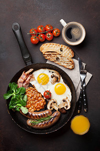 英语早餐炒鸡蛋香肠培根豆子吐司番茄橙汁和石图片