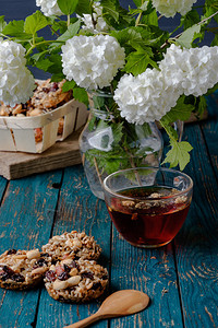 一杯茶和用坚果和葡萄干制成的饼干图片