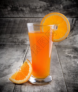 橙汁玻璃和木头上的新鲜橙子图片