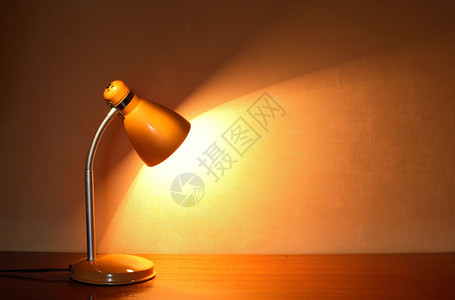 现代黄色光亮桌台灯在墙壁附近的桌子图片