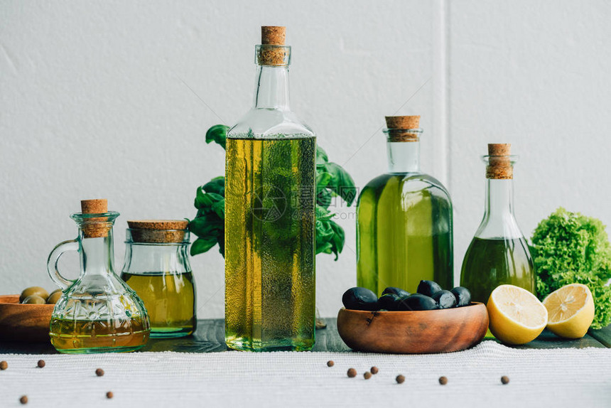 木桌上的橄榄油瓶和蔬菜图片
