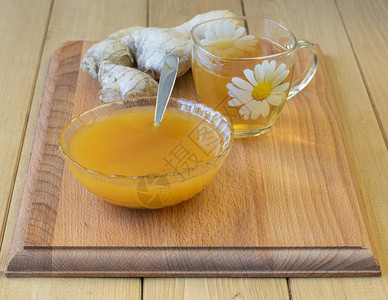 生姜和蜂蜜在木制桌上的根图片