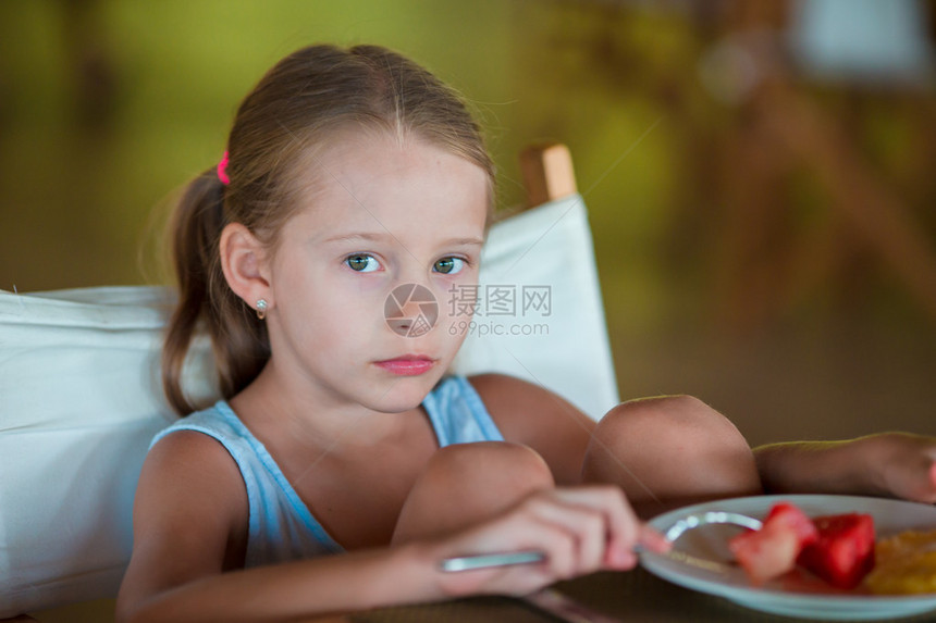 可爱的小女孩在度假餐厅吃图片