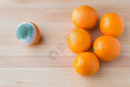 木制桌上的新鲜橙子附近有腐图片
