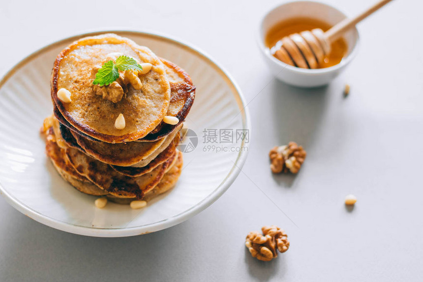 香蕉煎饼配有核桃和雪松坚果蜂蜜和薄荷图片