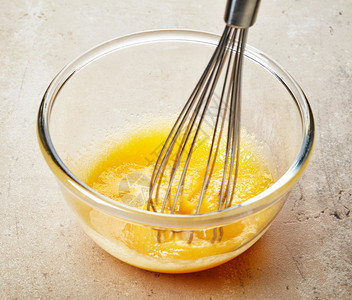 在玻璃碗里加糖的搅打蛋黄图片