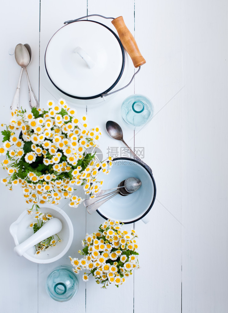 洋甘菊花白色搪瓷炊具玻璃瓶白色木质背景上的复古勺子舒适的乡村风格装饰图片