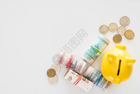 黄色小猪银行和各种滚动俄罗斯钞票的高视图图片