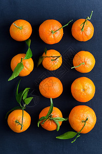 深蓝色布上的多个成熟橘子俯视图背景图片