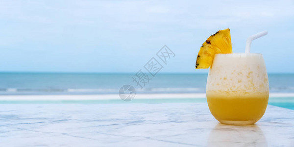 大理石桌边有蓝色热带海滩的菠萝冰淇淋图片