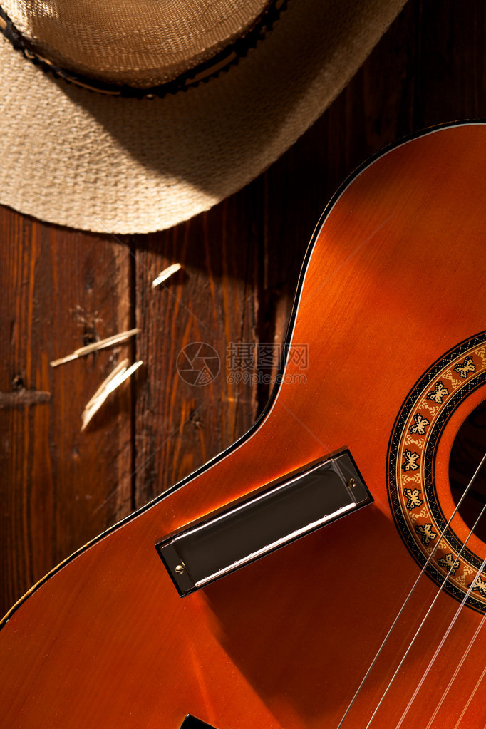 吉他上的口琴木头上的牛仔帽图片