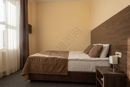 现代酒店卧室内部配有棕色床图片