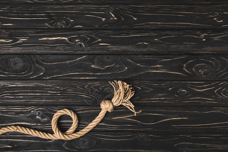 深色木质表面打结的棕色航海绳索的顶部视图背景图片
