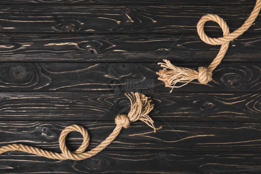 木板上打结的棕色航海绳索的顶部视图图片