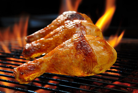 火焰状烤架上的烤鸡腿图片