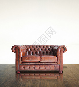 经典的棕色真皮沙发和旧木背景图片