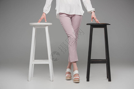 在灰色背景椅间站立的女模图片