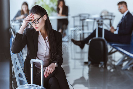 疲倦的女商人坐在机场候机室图片