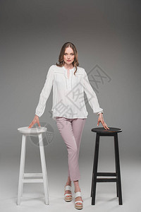 优雅的女士用灰色背景在两张椅图片