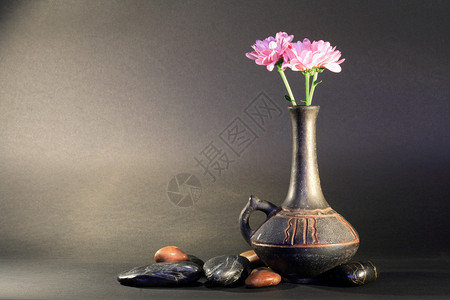 古老的陶瓷花瓶在黑暗背景的石头附近有美图片