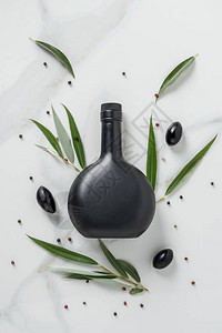 大理石桌上黑瓶橄榄油和橄图片