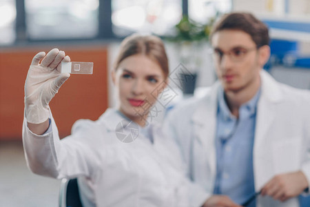 白色大衣中的化学家在实验室查看图片