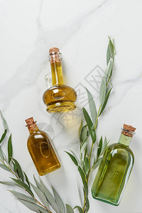 大理石桌上三瓶橄榄油和树图片