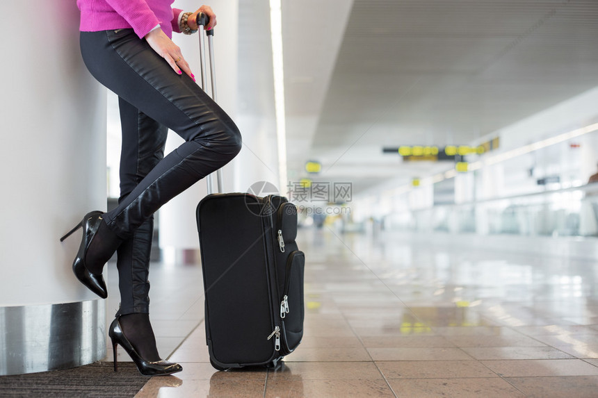 女人站在机场提着行李图片