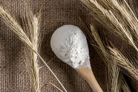 木勺中面粉和麻布上小麦的近景图片