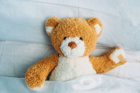 近距离看着可爱的泰迪熊玩具躺在床上图片