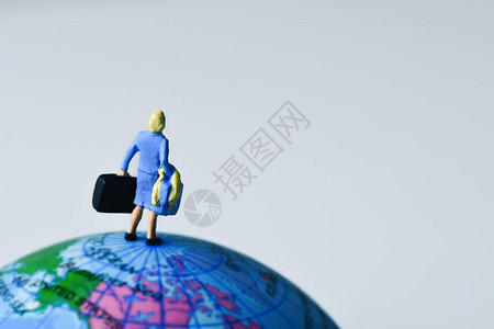 从后面看到的女小型旅行者在地球的顶端携带一些手提行李箱图片