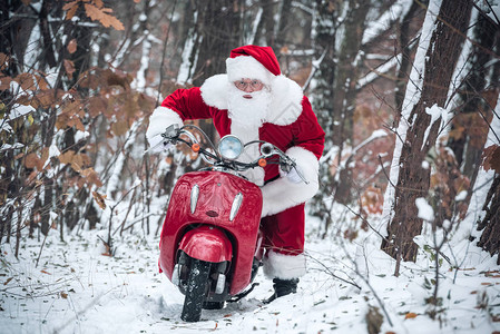 圣诞老人骑着红色的摩托车在雪路图片