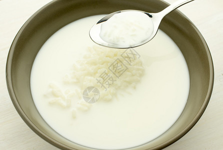 牛奶汤碗里有米糊汤匙里有汤背景图片