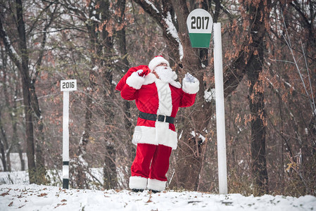 圣诞老人在雪路上行走背上满是礼背景图片