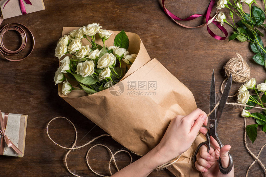 以旧剪刀砍绳子为包纸中的白玫瑰花束的旧剪图片