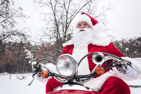 圣诞老人骑着红色摩托车在图片