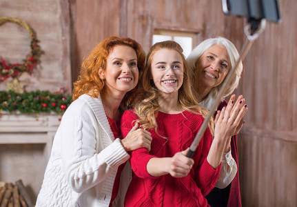 幸福的三代家庭在装饰圣诞壁炉前自拍背景图片