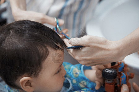 梳理婴儿头发的理发师的手图片