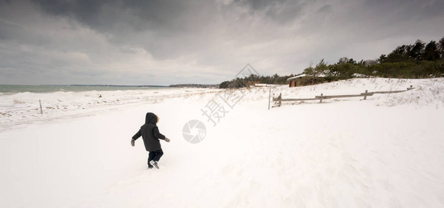 儿童在雪中行走图片