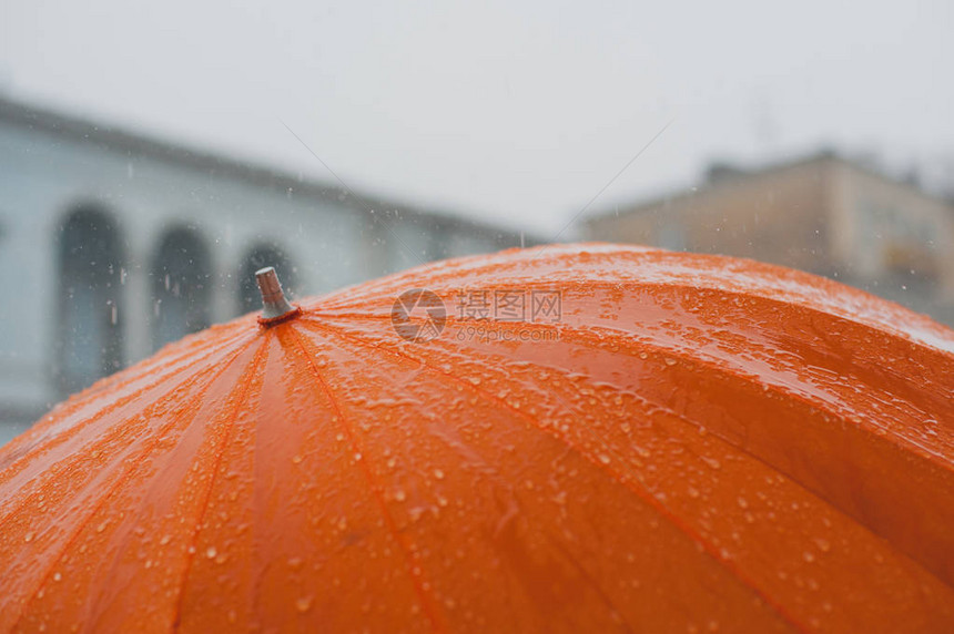 雨滴从橙色雨伞上落下图片