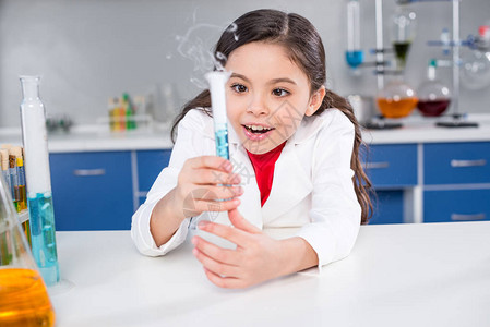 兴奋的小女孩在化学实验室内观看带图片