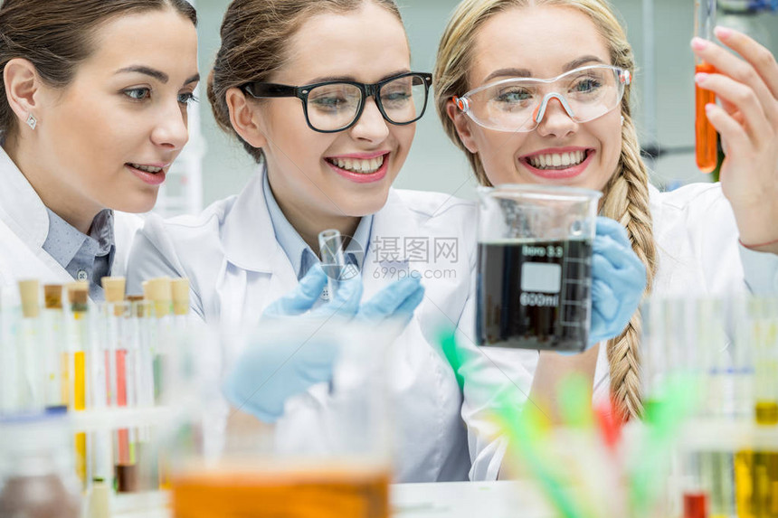 年轻笑着微笑的女科学家在化学实验图片